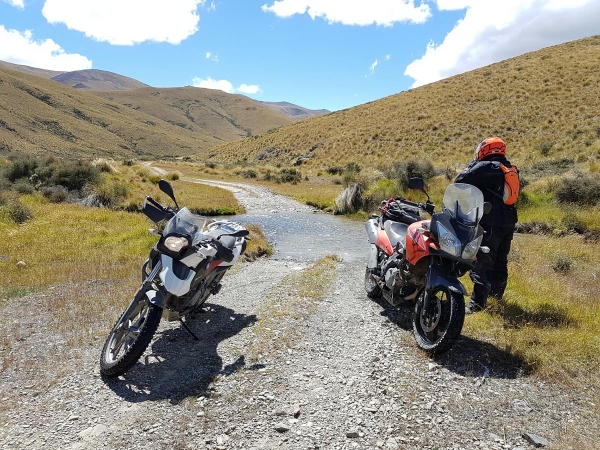Riders take a break after crossing a small ford on East Manuherikia Track