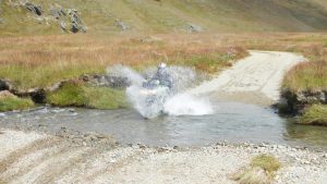 A KLR rider gest enthusiatic on a river crossing.